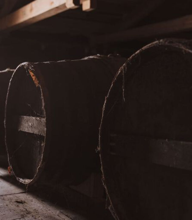 A lifestyle photo of LOUIS XIII barrels in a dark cellar
