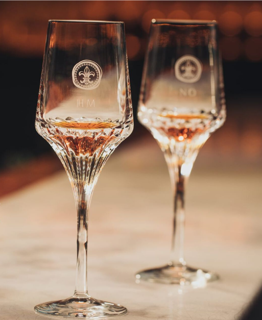 A lifestyle photo of two crystal glasses with cognac on a bar countertop