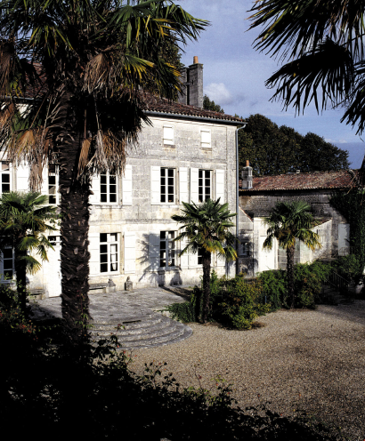 A photo of an entry to a white bulding entoured by palms