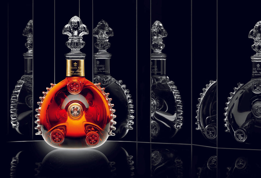 A lifestyle photo of LOUIS XIII decanter on a black surface, black background, mirror reflections on both sides