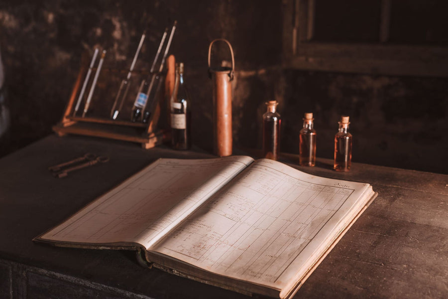 A lifestyle photo of LOUIS XIII registry book, cognac samples in the background