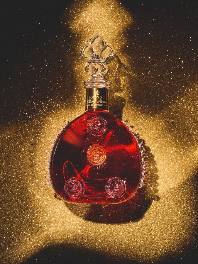 A lifestyle image of LOUIX XIII Classic decanter on a background of golden dust