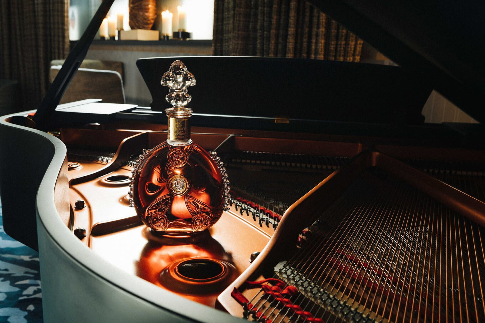 A lifestyle photo of LOUIS XIII decanter standing inside a piano